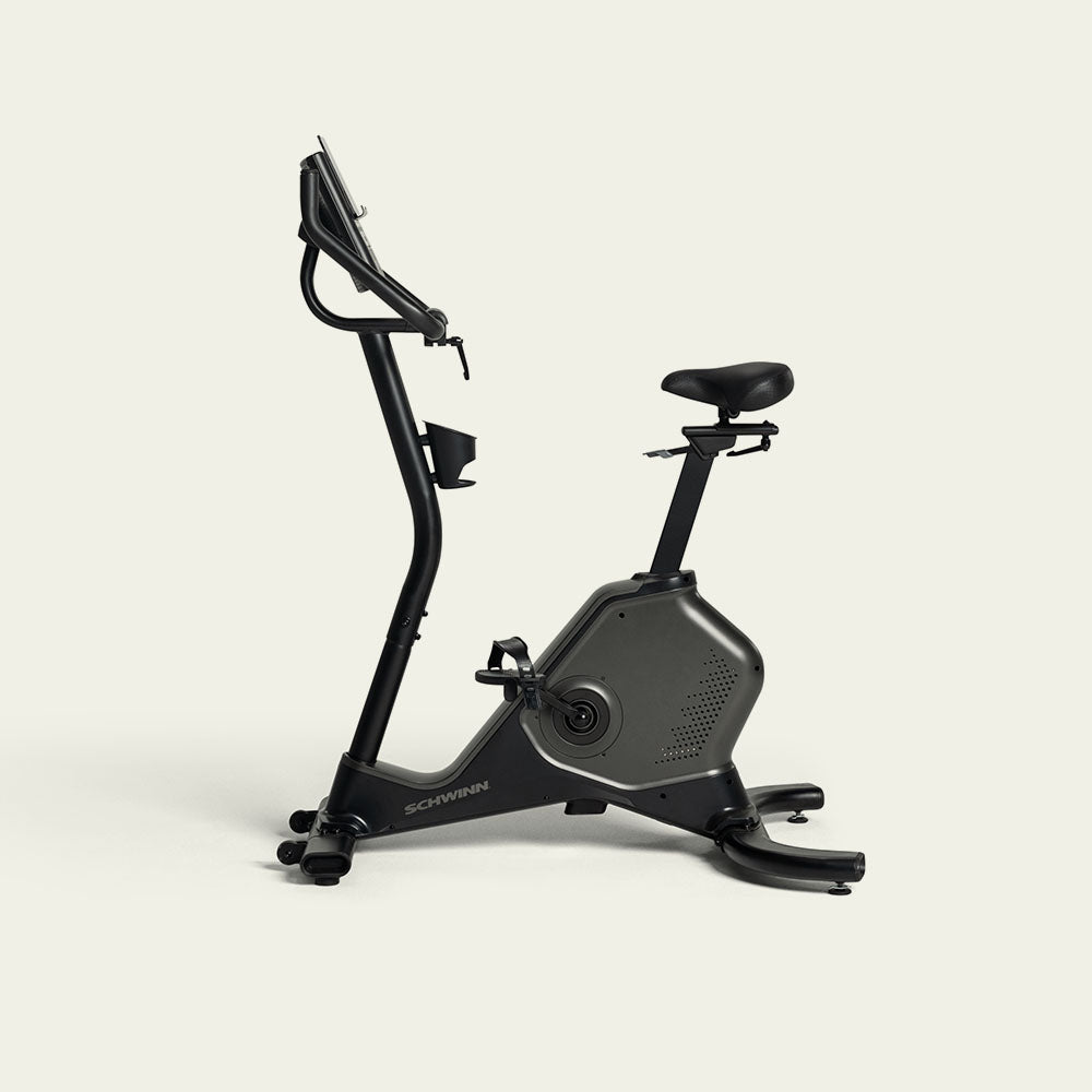 Black and dark gray upright exercise bike on a light beige background