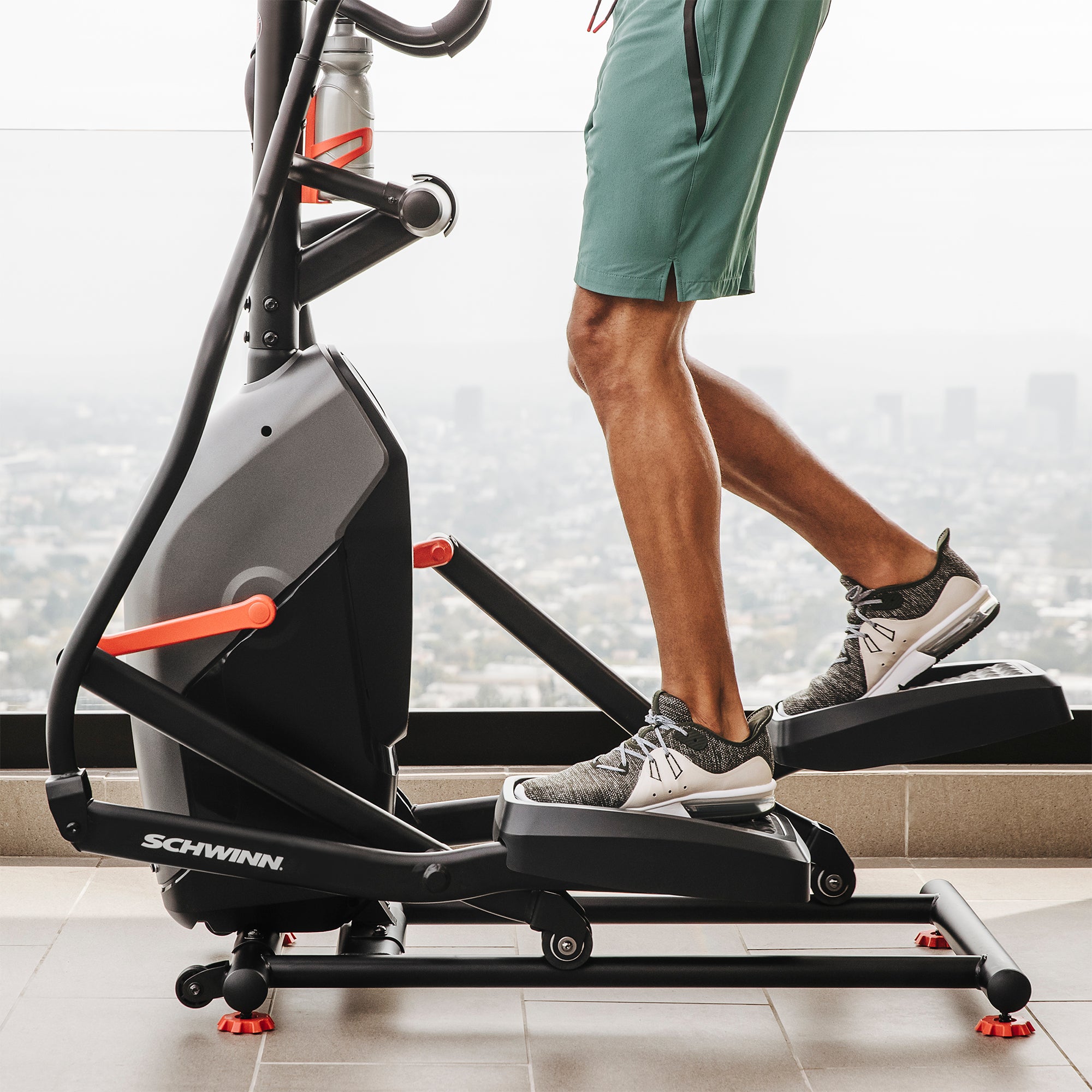 Person using a Schwinn elliptical machine in a home setting.