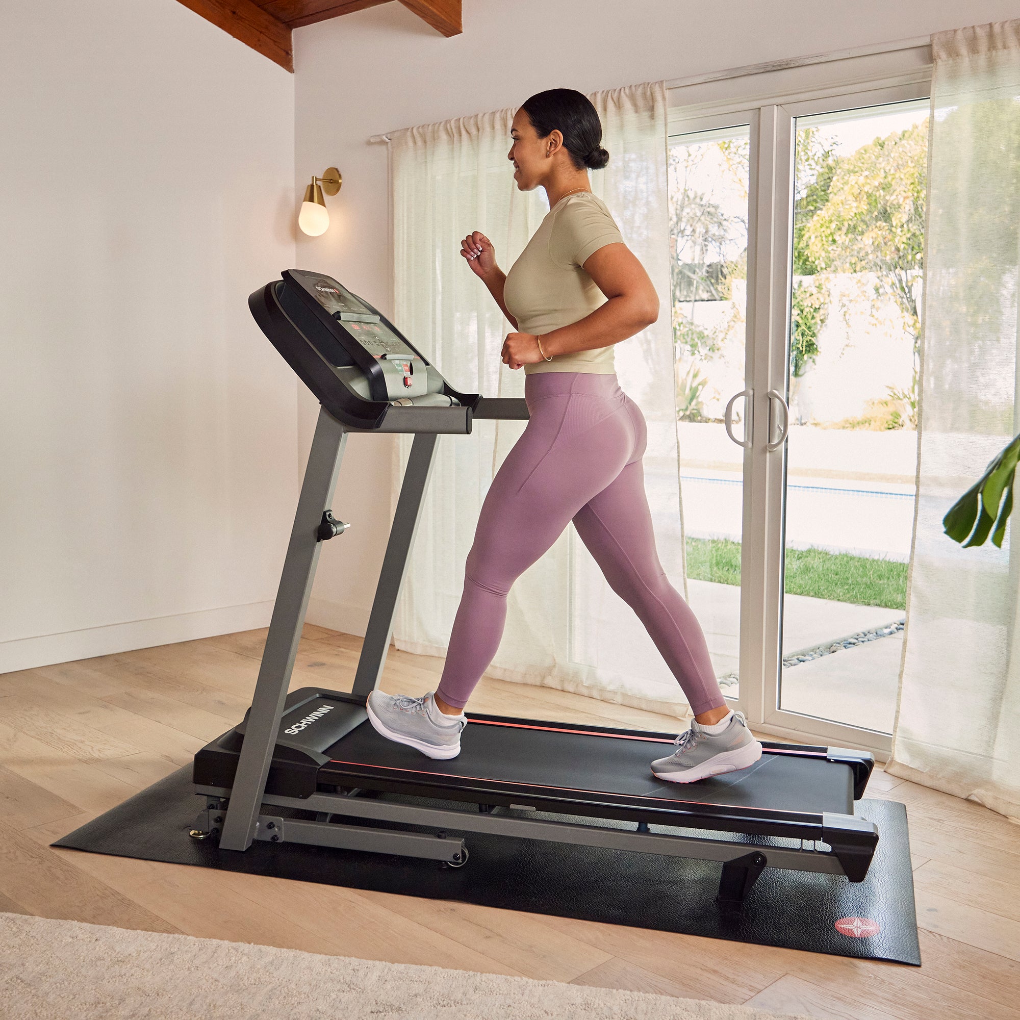 Woman walking on a treadmill in a home setting